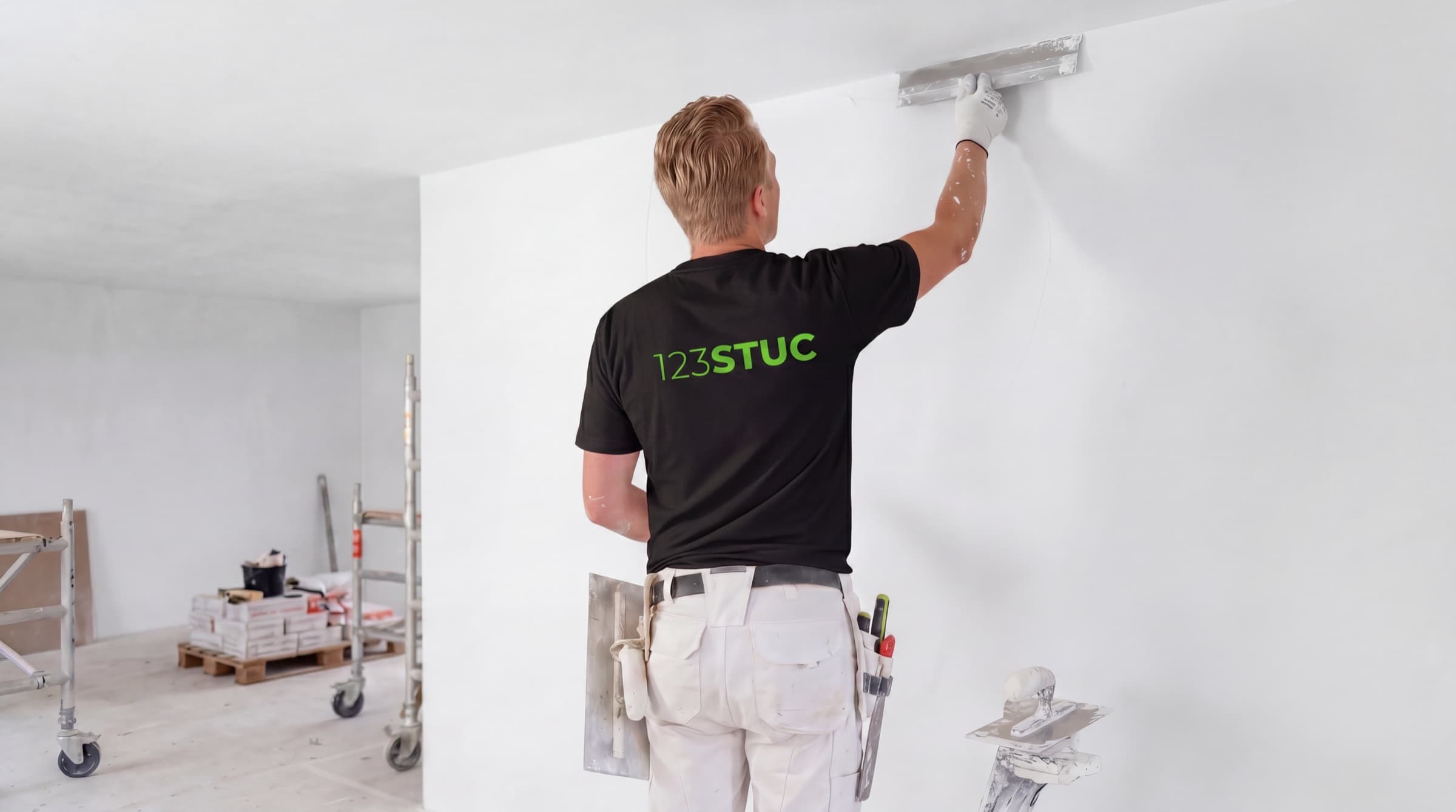Stukadoor van 123STUC pleistert een wand in een nieuwbouwwoning